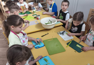 Dzieci obierają i kroją ogórki