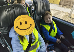 Na zdjęciu widzimy dwójkę dzieci siedzących w autokarze.