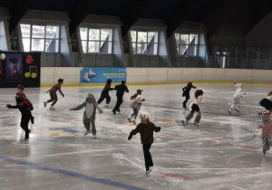 Na zdjęciu widzimy dzieci, które tańczą na lodzie.