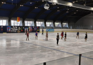 Na zdjęciu widzimy dzieci, które tańczą na lodzie.