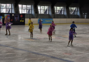Na zdjęciu widzimy dzieci, które tańczą na lodzie.