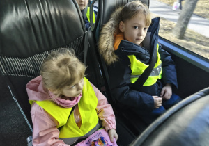 Na zdjęciu widzimy dwójkę dzieci siedzących w autokarze.