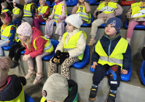 Na zdjęciu widzimy dzieci, które oglądają występy na lodzie.