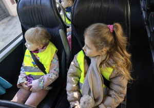 Na zdjęciu widzimy dwójkę dzieci siedzących w autokarze.