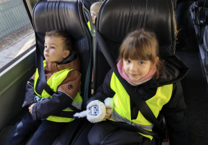 Na zdjęciu widzimy dwójkę dzieci siedzących w autokarze.