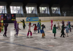 Na zdjęciu widzimy dzieci, które tańczą na lodzie.