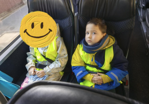 Na zdjęciu widzimy dwójkę dzieci siedzących w autokarze.