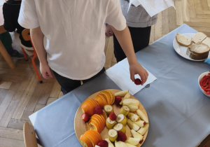 Na zdjęciu widzimy Jubilata, który częstuje się owocami.