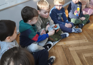 Na zdjęciu widzimy chłopców, którzy oglądają zdjęcia Jubilata.