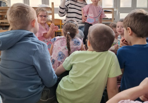 kobieta czyta książkę grupie dzieci