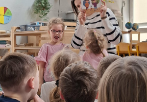 kobieta pokazuje ilustracje w książce