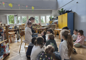 Na zdjęciu widzimy mamę Anastazji, która czyta dzieciom książkę o Jadzi.