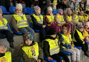 Zdjęcie przedstawia dzieci siedzące na widowni.