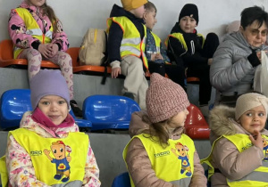 Zdjęcie przedstawia dzieci siedzące na widowni.