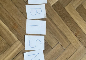 Zdjęcie przedstawia kolejno ułożone kartki, które tworzą napis przebiśnieg.