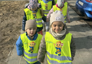 Zdjęcie przedstawia dzieci idące w parach podczas spaceru.