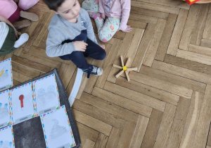 Na zdjęciu widzimy chłopca, który z klcoków drewnianych zrobiła słoneczko.