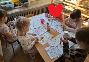 Na zdjęciu widzimy dzieci, które wycinają ilustrację przedstawiające stany pogody marcowej.