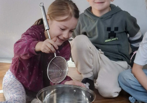 Na zdjęciu widzimy chłopca, który miesza ilustrację pogody marcowej w garnku za pomocą łyżki.