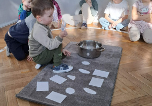 Na zdjęciu widzimy chłopca, który trzyma w ręku ilustrację przedstawiającą stany pogody marcowej.