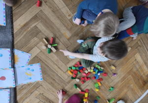 Na zdjęciu widzimy chłopca, który pokazuje koledze wykonane słoneczko z klocków drewnianych.