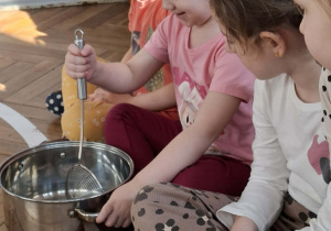 Na zdjęciu widzimy chłopca, który miesza ilustrację pogody marcowej w garnku za pomocą łyżki.