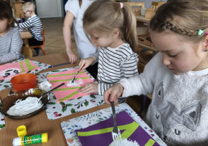 Na zdjęciu widzimy dziewczynki, które wykonują prace plastyczą - panda.