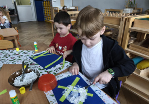 Na zdjęciu widzimy chłopców, którzy wykonują prace plastyczną - panda.