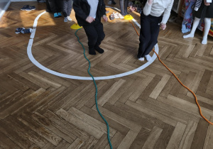 Na zdjęciu widzimy dzieci, które wykonują ćwiczenia sprawnościowe.