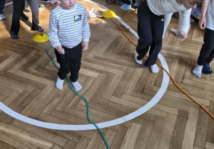 Na zdjęciu widzimy dzieci, które wykonują ćwiczenia sprawnościowe.