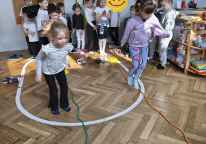 Na zdjęciu widzimy dzieci, które wykonują ćwiczenia sprawnościowe.