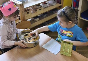 Na zdjęciu widzimy Jubilatkę częstującą chłopca babeczką.