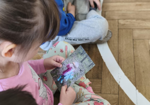 Na zdjęciu widzimy dziewczynkę oglądającą zdjęcie Jubilatki.