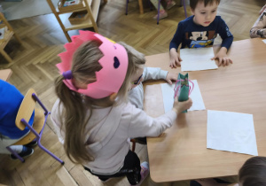 Na zdjęciu widzimy Jubilatkę, która wręcza chłopcu drobny prezent.