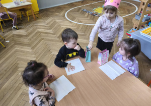 Na zdjęciu widzimy dziewczynkę, która wręcza dzieciom drobne upominki.