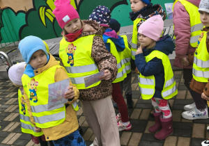 dzieci w kamizelkach, trzymają w rękach zdjęcia kwiatów