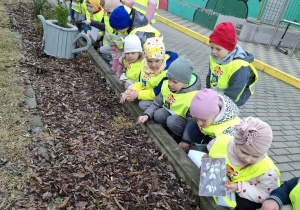 dzieci przyglądają się gabacie z kwiatami