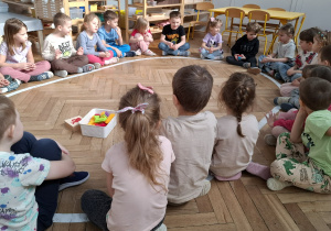 dzieci siedzą w kręgu