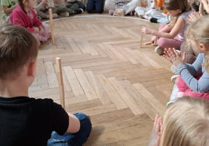 troje dzieci układa wieże z klocków, pozostałe dzieci klaszczą w dłonie