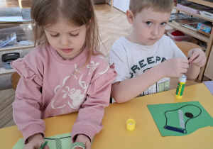 dzieci przy stolikach, wykonują prace plastyczne