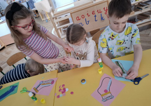 dzieci przy stolikach, wykonują prace plastyczne
