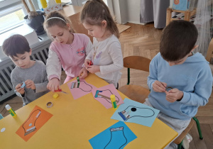 dzieci przy stolikach, wykonują prace plastyczne