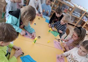 dzieci przy stolikach, wykonują prace plastyczne