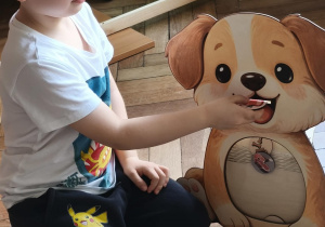 Dziecko sprawdza co pies może jeść wkładając wybrany produkt do psiej zabawki