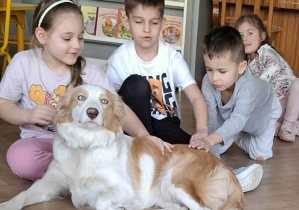 Dzieci głaszczą psa