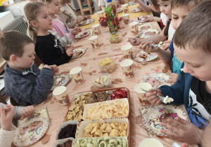 Dzieci siedzą przy stole urodzinowym