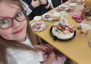 Dzieci siedzą przy stole urodzinowym