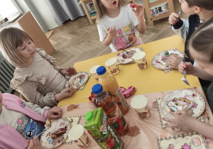 Dzieci siedzą przy stole urodzinowym