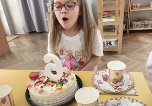 Dziewczynka dmucha świeczkę