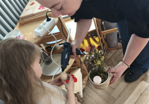 Dzieci przyklejają wydmuszki pod kontrola mamy Zosi